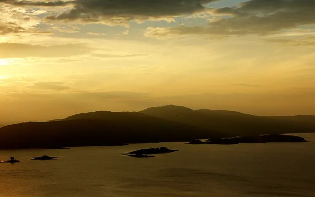 Supa Dam backwaters reflecting the forest at sunset near Dandeli