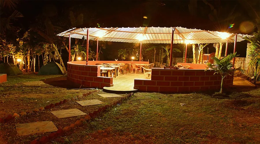 Night view of Golghar dining pavilion and tents at Dandeli River Edge Resort