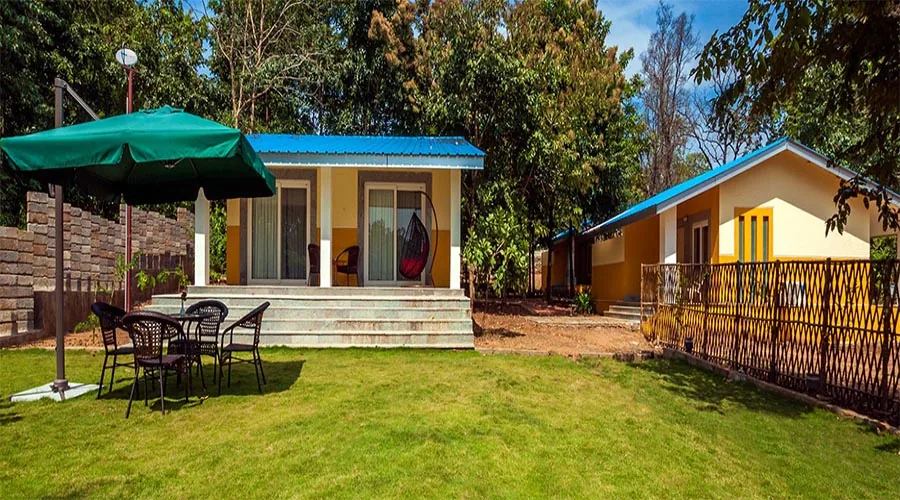 Cottages and lawn at Whistling Woods Dandeli