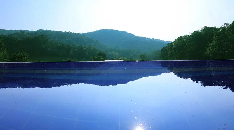 Infinity pool overlooking forested mountains at Dark Forest Resort Homestay Dandeli