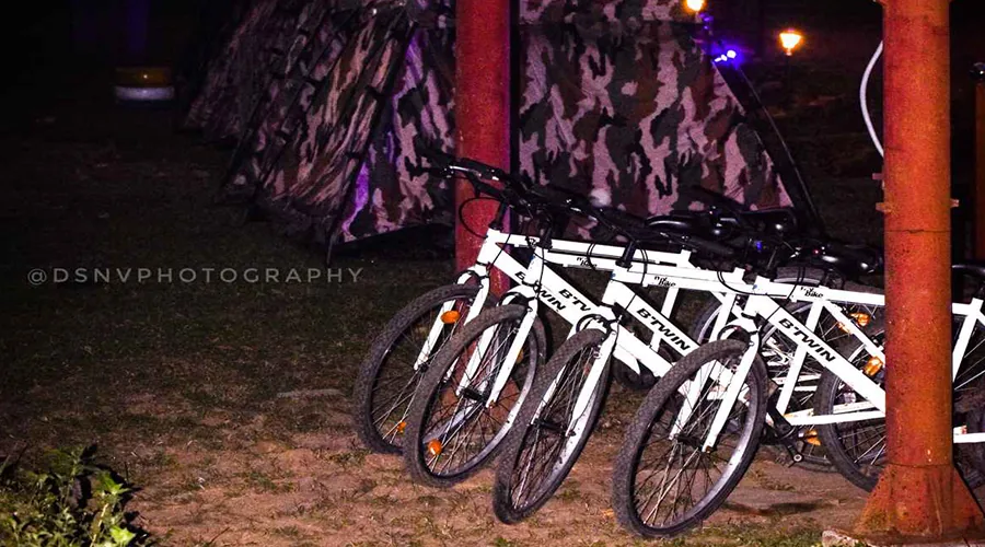 Mountain bikes parked beside camouflage tents at Hidden Valley Dandeli