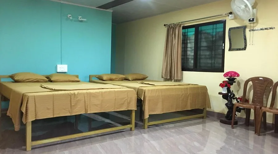 Twin beds in a teal and yellow cottage room at Lemon Tree Jungle Stay